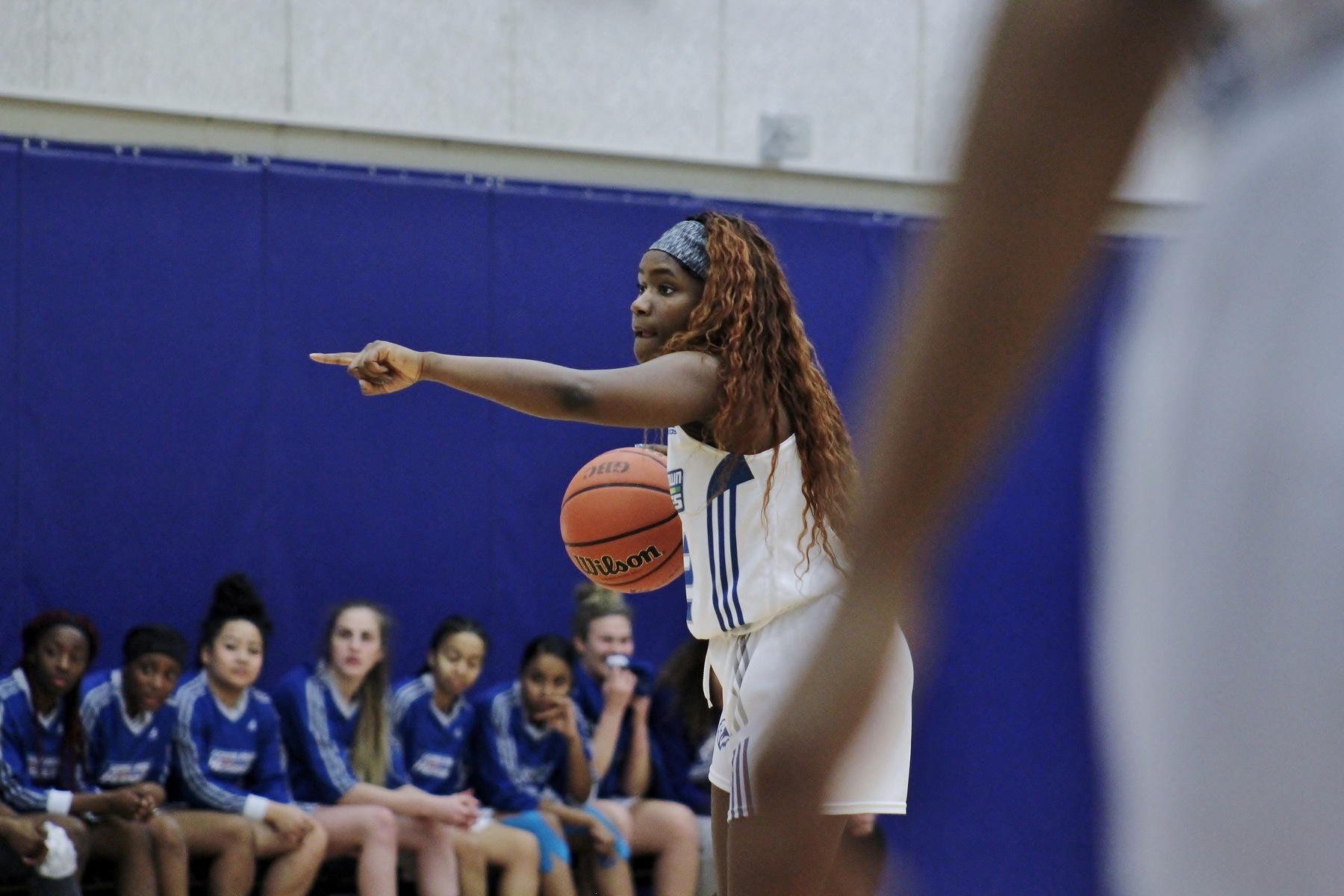 Female basketball player dribbling and pointing