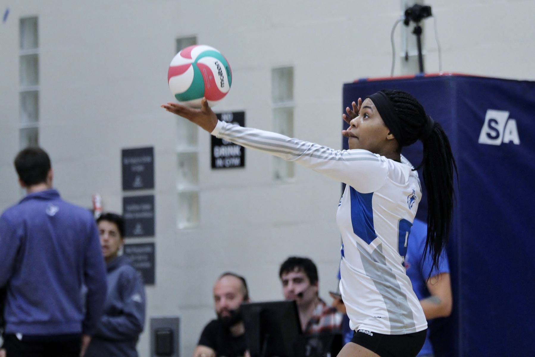 Women's volleyball player holds ball to serve